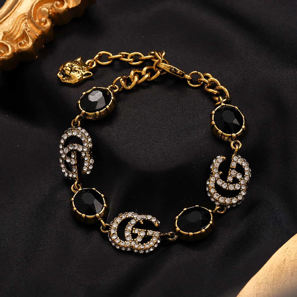 Set di orecchini, bracciale e collana in lega con logo impresso