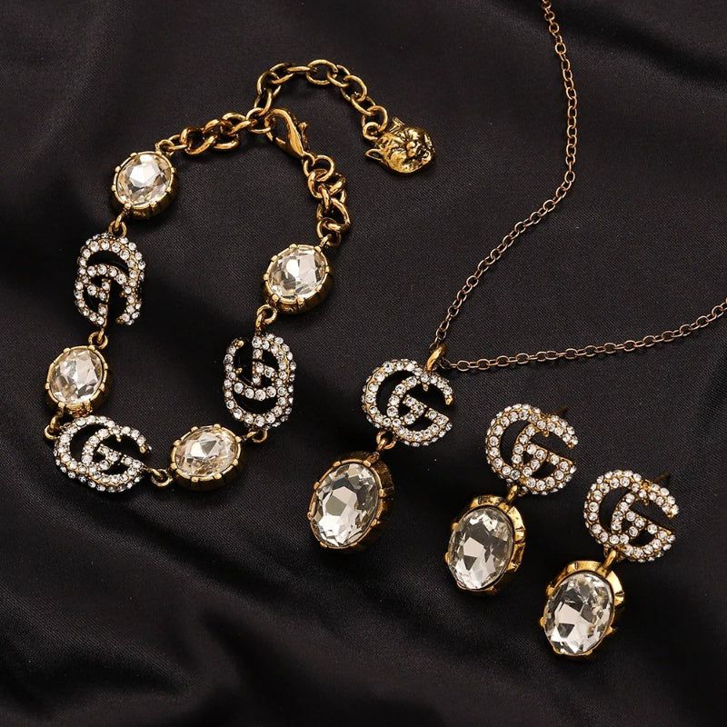 Set di orecchini, bracciale e collana in lega con logo impresso